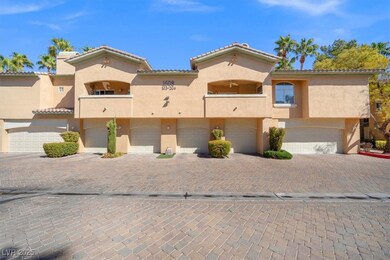 View of front of house with a tile roof, a garage,