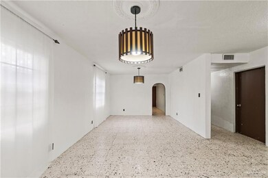 Unfurnished room with tile patterned floors, arched walkways, and visible vents