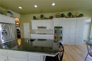 Island with prep sink view, double ovens, and stor