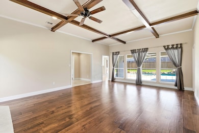 Living room view out to the pool with coffered ceiling, beamed ceiling, wood floors, and ceiling fan