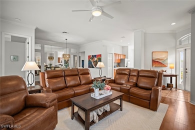 Living room featuring crown molding, wood finished floors, ceiling fan, and recessed lighting
