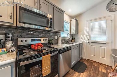 Kitchen with decorative backsplash, gray cabinets,