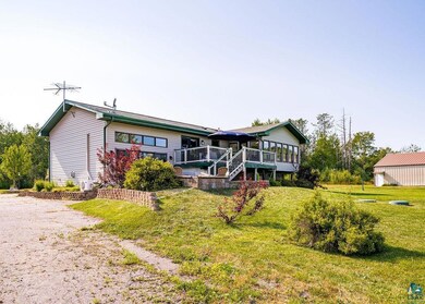View of rear facade with a deck and back lawn