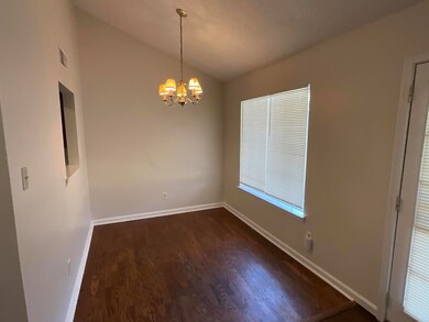 Unfurnished dining area with a chandelier, dark wo