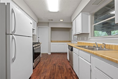 Kitchen with light countertops, a sink, white cab