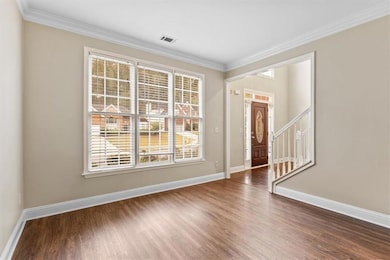 Entrance foyer featuring ornamental molding, wood finished floors, and stairway