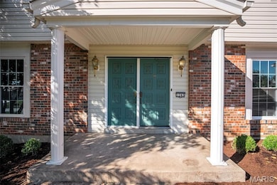 Doorway to property with covered porch and brick siding