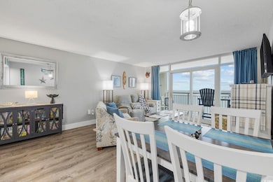 Dining area with floor to ceiling windows, a textured ceiling, baseboards, and wood finished floors