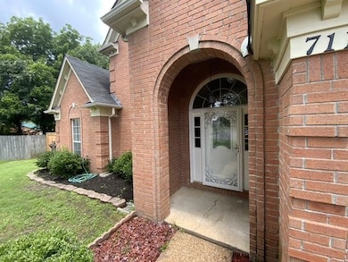 Doorway to property with brick siding and a shingled roof