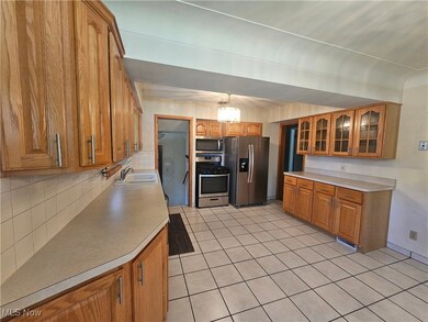 Kitchen with tile floors, oak cabinets, stainless steel appliances
