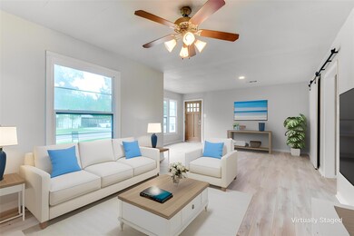 Living room featuring a barn door, light hardwood 