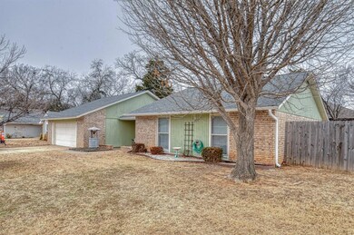 Ranch-style home featuring a front yard and a gara