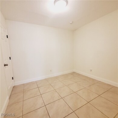 Spare room with light tile patterned flooring and baseboards