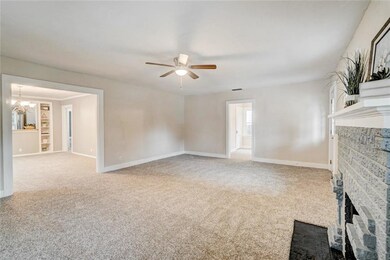 Looking from the SE corner of the living area you can see bedroom #3 in the distance.  Check out the detail on the fireplace from this view, as well.  Plus to the left of the picture you can see the dining area.