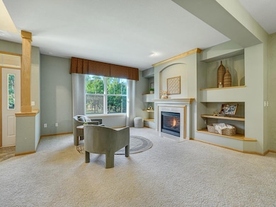 Expansive windows fill the home with natural light while offering stunning views of lush green space and the Rum River.