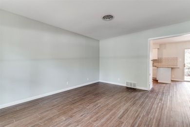 Empty room with baseboards and dark wood-type flooring