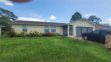 Single story home with a garage and a front lawn