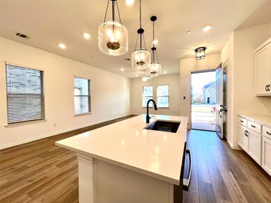 Kitchen with dark wood finished floors, light countertops, visible vents, and a sink