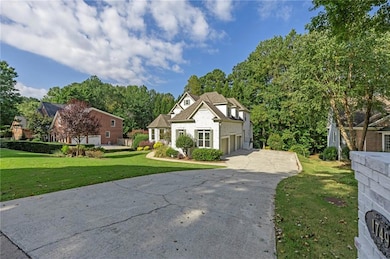 French provincial home featuring a front lawn and concrete driveway