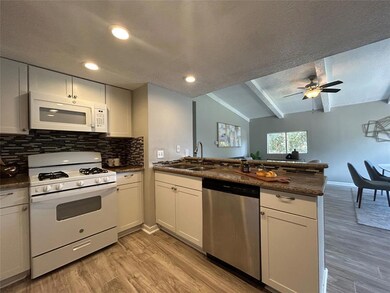 Kitchen featuring white appliances, a sink, a pen