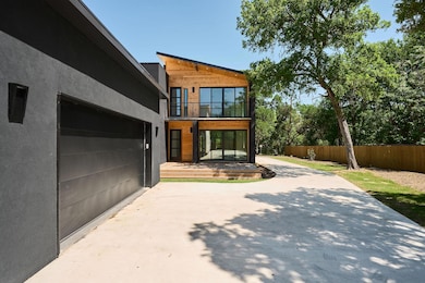 View of side of property with a balcony, fence, a