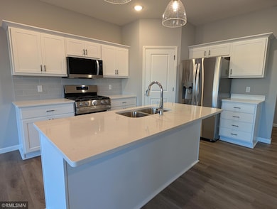 The kitchen features modern, contemporary finishes with brand-new appliances, sleek white cabinets, and a spacious corner pantry.