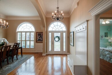 Welcoming Entry Foyer Hardwood floors, Chandelier, Plantation Shutters and Crown Molding.