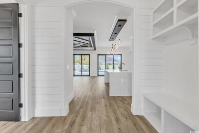 Mudroom with a chandelier, sink, and light hardwoo