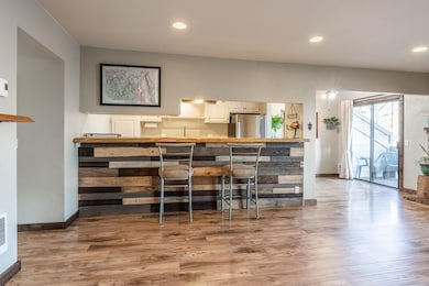 Bar area featuring recessed lighting, freestanding refrigerator, laminate flooring