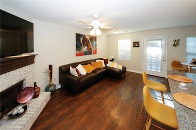 Living room featuring a textured ceiling, a brick 
