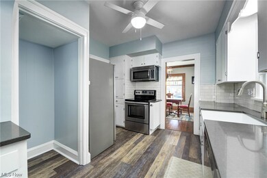 Kitchen updated in (2018) with stainless steel appliances, backsplash, and dark hardwood / wood-style floors and Farmhouse sink.