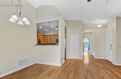 Dining room with ceiling fan with notable chandeli