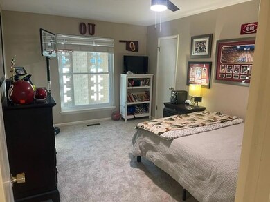 Carpeted bedroom featuring ceiling fan