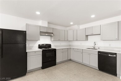 Kitchen featuring black appliances, a sink, under
