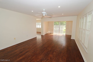 Spare room with a healthy amount of sunlight, dark hardwood / wood-style floors, and ceiling fan