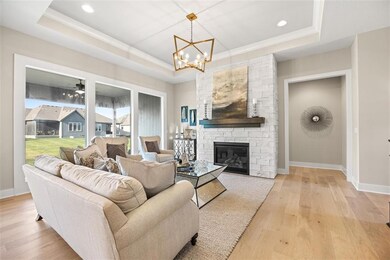 Gas fireplace with floor to ceiling stone surround and wood mantle.