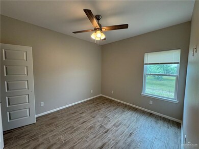 Empty room with wood finished floors, a ceiling fan, and baseboards