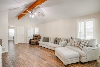 Living room with plenty of natural light, wood finished floors, and a ceiling fan