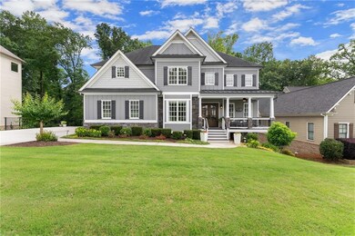 View of front facade with board and batten siding, a porch, a front yard, stone siding, and a standing seam roof