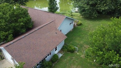 Aerial view of property and surrounding area featuring a nearby body of water