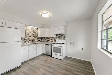 Kitchen featuring white appliances, a sink, under
