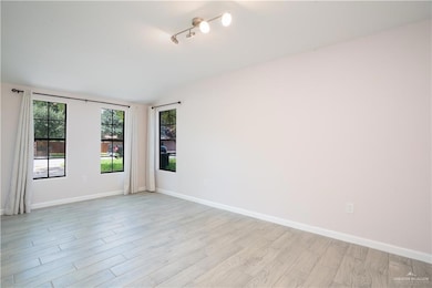 Living and Foyer with tracklighting and wood-style tile floors