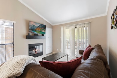 The cozy living room has a balcony to the side, pr