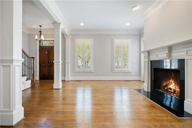 Unfurnished living room featuring a chandelier, light wood-style floors, crown molding, a fireplace, and stairway