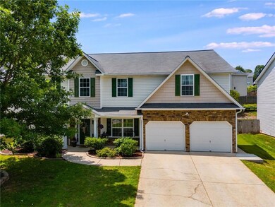 Traditional-style home featuring concrete driveway, an attached garage, and a shingled roof