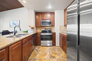 Kitchen with appliances with stainless steel finishes, granite countertops