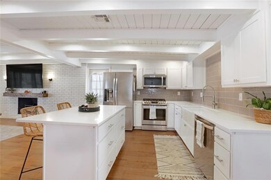 Spacious kitchen with bright white cabinets and qu