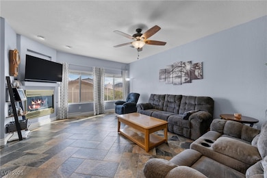 Living room featuring stone tile floors, baseboard
