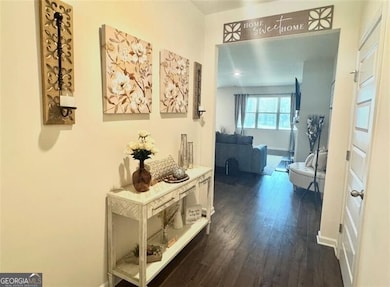 Corridor featuring baseboards and dark wood-style flooring