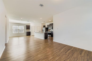 Unfurnished living room featuring dark wood-style flooring and recessed lighting